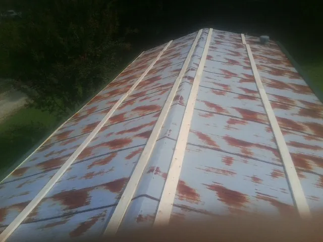 Rusted metal roof panels with new wood purlins before replacement — Storm Damage Roof Repair in Clarksdale by Roofing Brothers