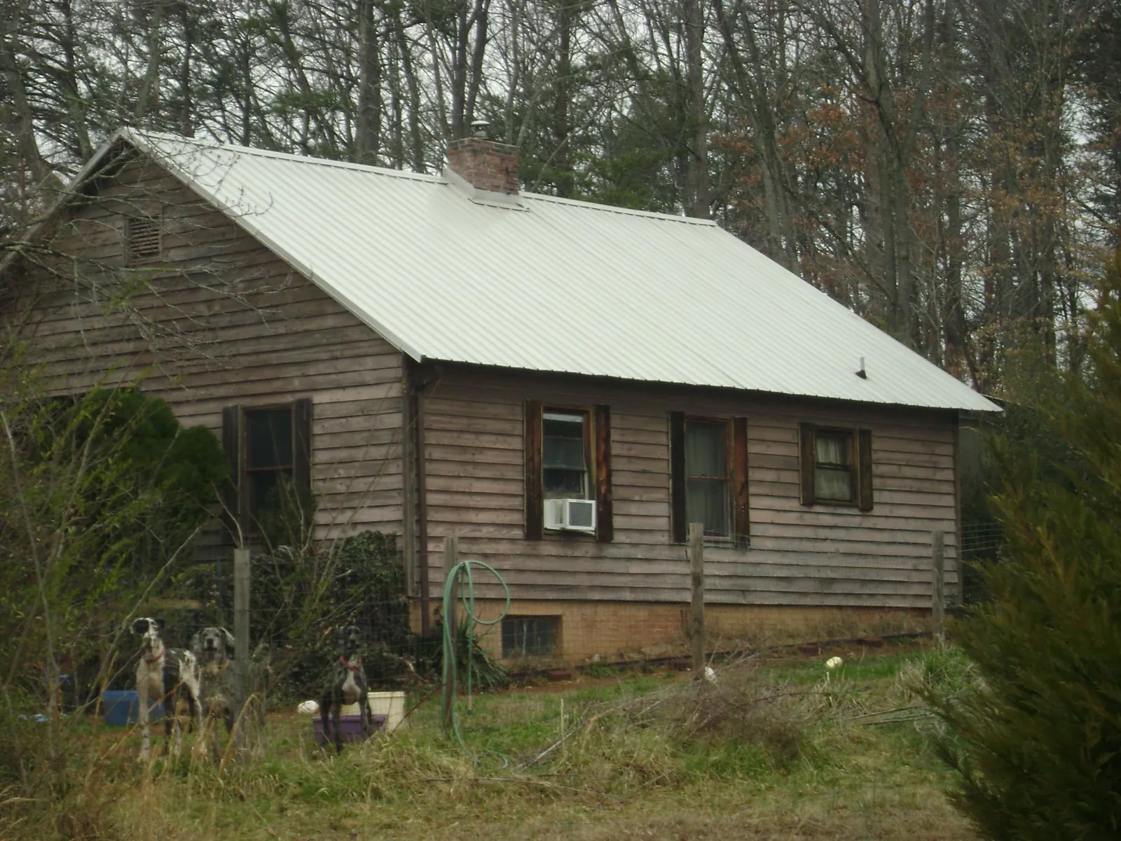 White metal roof on an old wood sided farmhouse, from a Metal Roof Installation job in Clarksdale